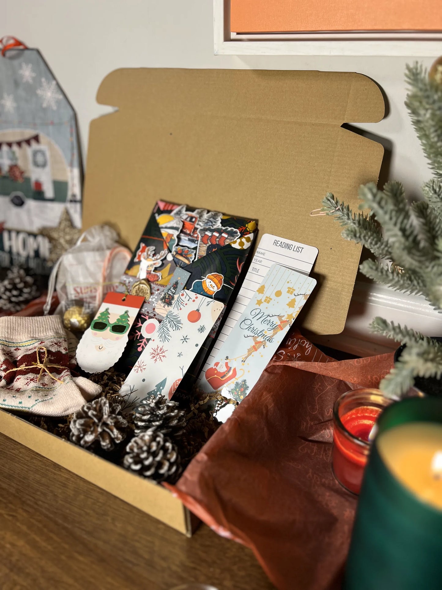 Christmas gift box with decorative items on a wooden surface.