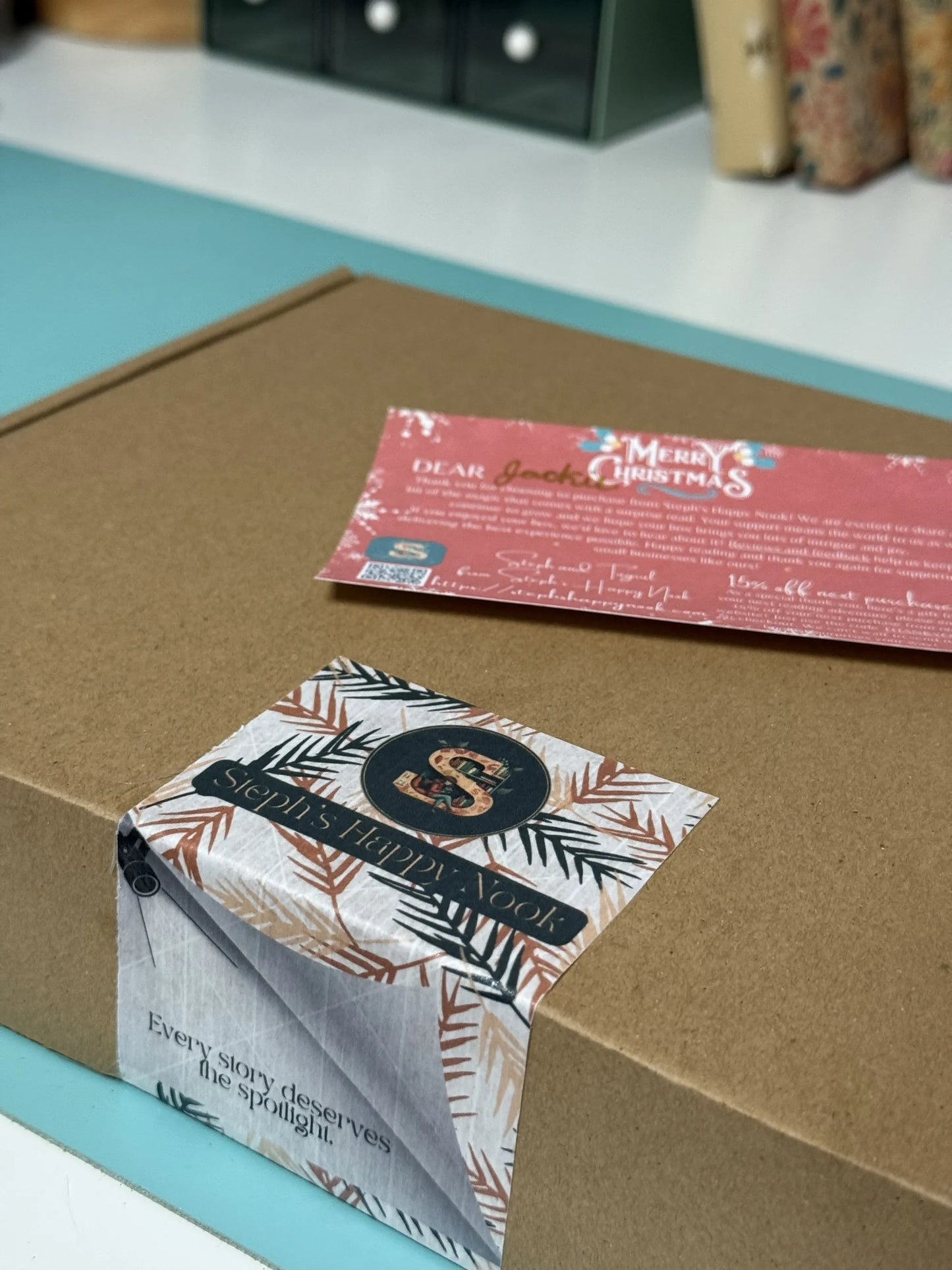 Box with a decorative label and a Christmas-themed card on it.
