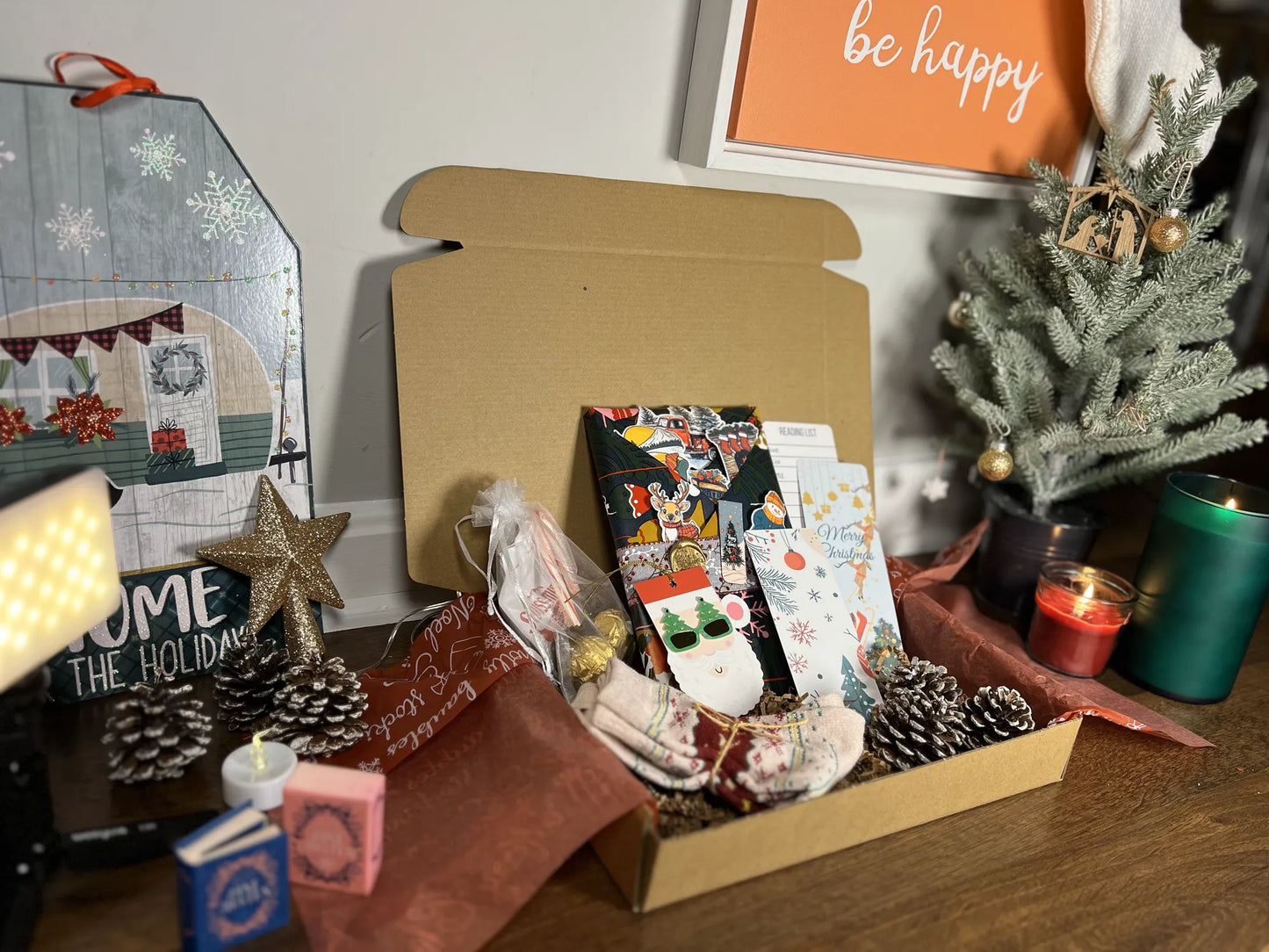 Decorative items including a box with greeting cards, a small Christmas tree, and festive decorations on a table.