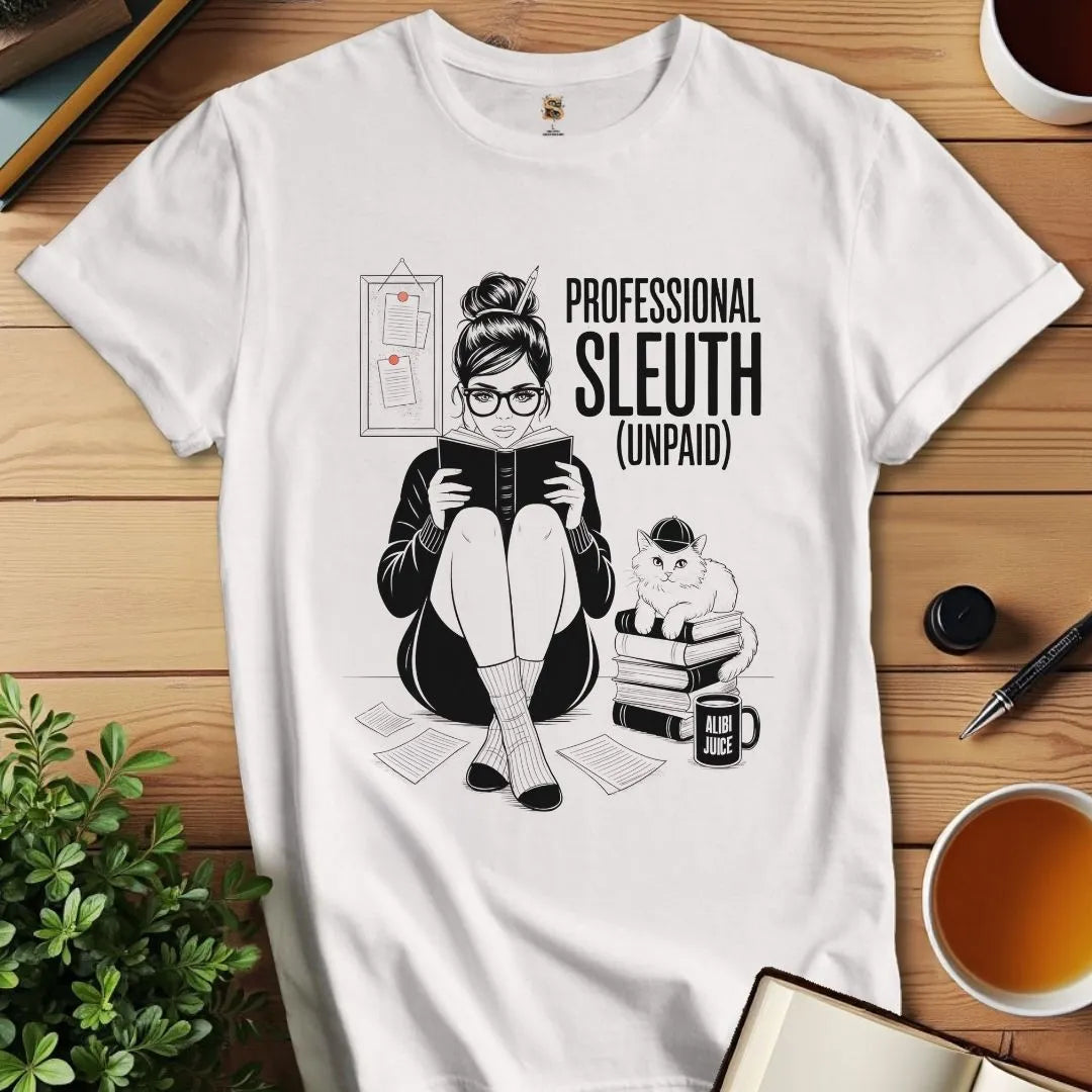 White t-shirt with a cozy mystery themed graphic design of a person reading a book with a cat, text sarcastically says 'PROFESSIONAL SLEUTH (UNPAID)' on a cozy reading place.